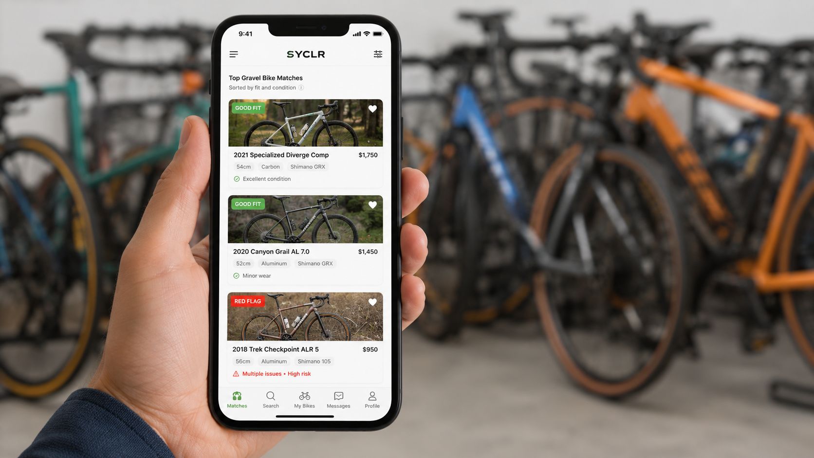 A hand holding a smartphone showing a gravel bike marketplace app listing used bikes for sale.
